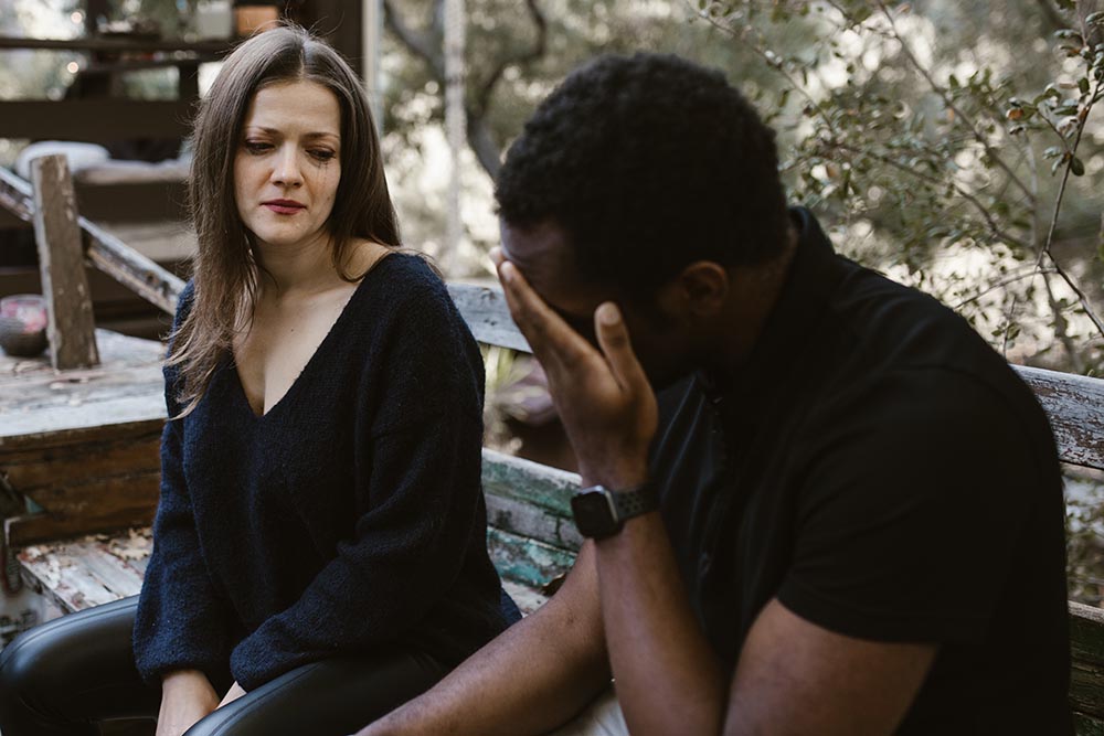 Brünette weiße Frau und schwarzer Mann sind unglücklich wegen Trennung