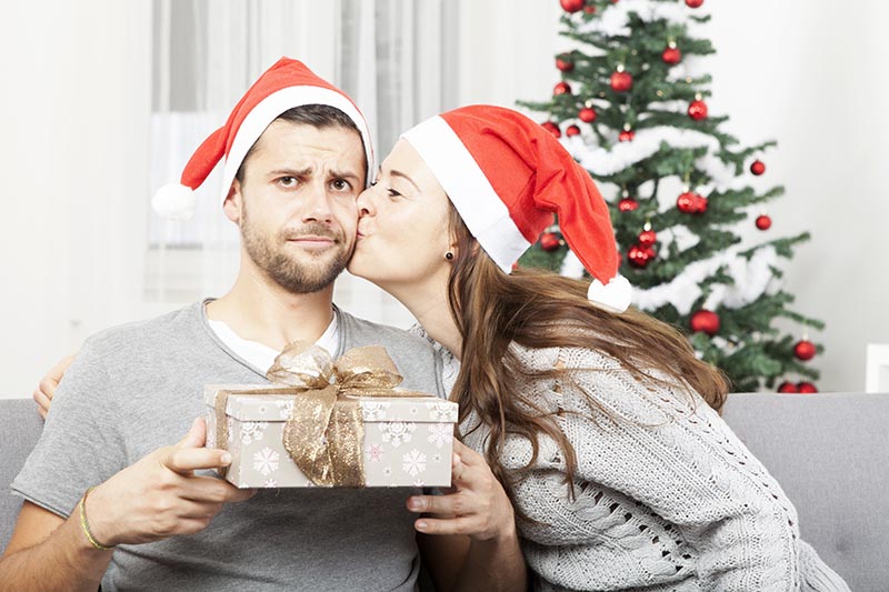 Ein junger Mann ist enttäuscht von dem Weihnachtsgeschenk seiner Partnerin