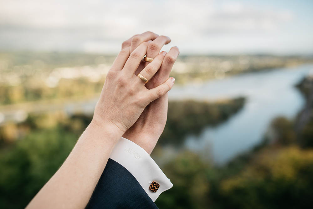 Seelenpartner halten ihre ineinander verschlungenen Hände mit Hochzeitsringen in die Kamera